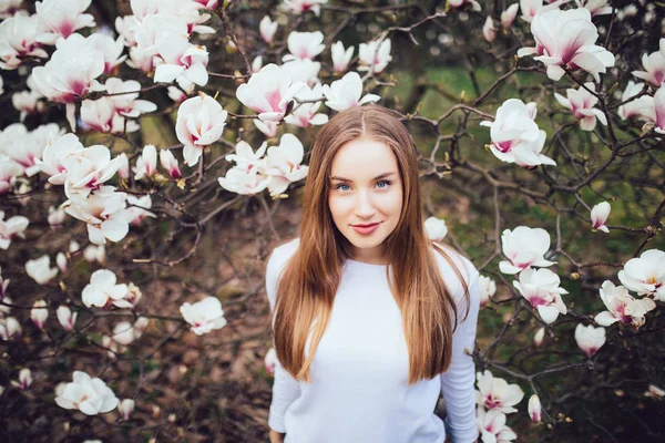 Bella donna in posa e magnolia bianca nel parco dall'alto. Sfondo primaverile — Foto Stock