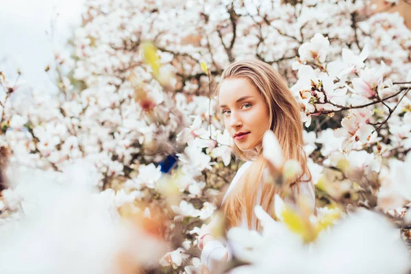 Bellezza donna intorno magnolia albero dei fiori rosa nel giardino primaverile — Foto Stock