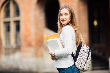 Öğrenci kız açık havada çanta ve kitaplar University yakınındaki