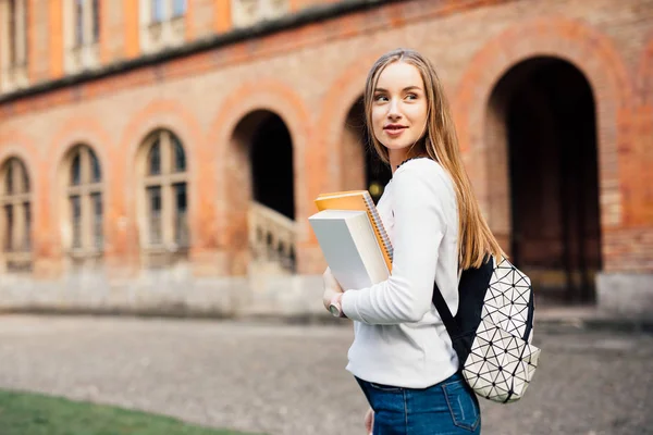 Estudante universitário feminino inteligente com saco e livros no campus ao ar livre — Fotografia de Stock