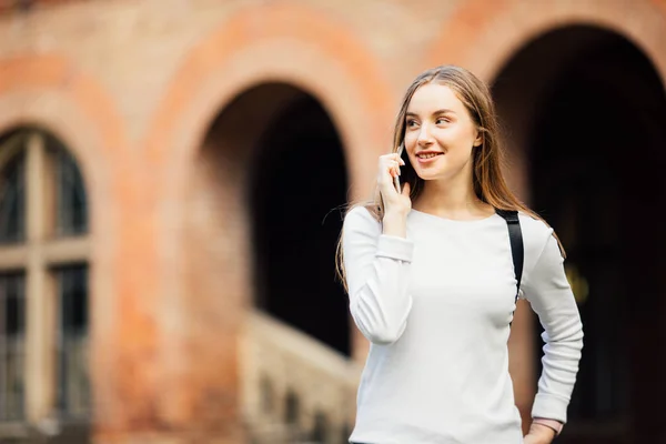 Menina estudante feliz falando móvel ao ar livre perto da Universidade — Fotografia de Stock