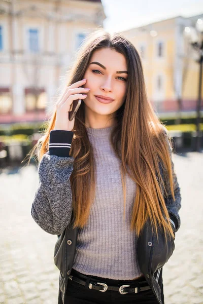 Joyeux jeune femme parle par téléphone portable dans la rue — Photo