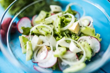 Taze salata, salatalık, turp ve ahşap masa üzerinde otlar. Üstten Görünüm