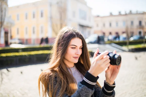 Estilo de vida sonriente al aire libre retrato de una mujer joven y bonita divirtiéndose en la ciudad en Europa con la cámara de viaje foto del fotógrafo haciendo fotos — Foto de Stock