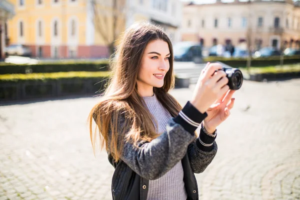 Retrato de una mujer joven, en forma y atractiva tomando una foto al aire libre. Chica mirando a la cámara . — Foto de Stock