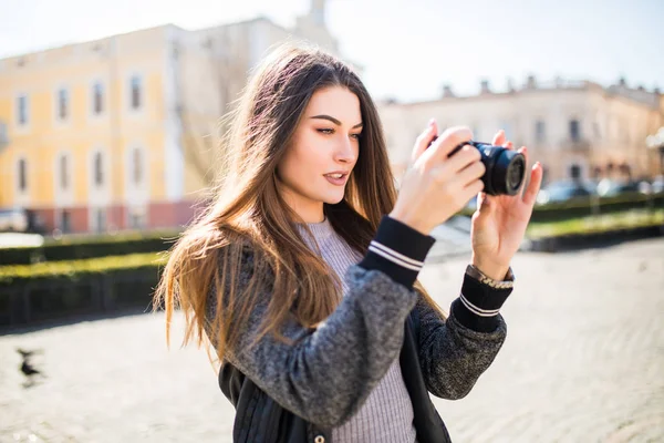 Retrato de una mujer joven, en forma y atractiva tomando una foto al aire libre. Chica mirando a la cámara . — Foto de Stock