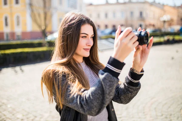 Estilo de vida sonriente al aire libre retrato de una mujer joven y bonita divirtiéndose en la ciudad en Europa con la cámara de viaje foto del fotógrafo haciendo fotos — Foto de Stock