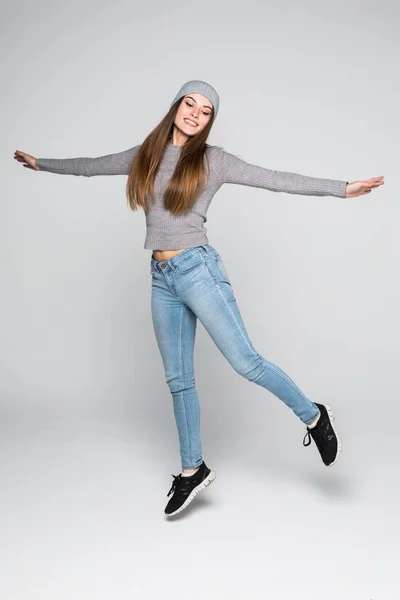 Szép boldog nő jumping az öröm, a szürke háttér — Stock Fotó