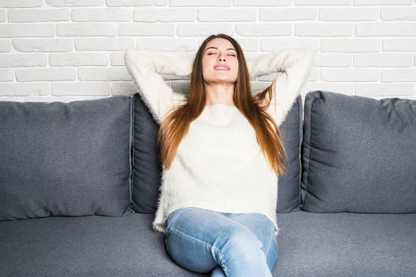 Relaxante mulher sentado confortável no sofá lounge cadeira sorrindo feliz olhando para a câmera . — Fotografia de Stock