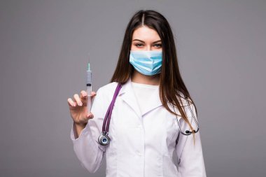 Doktor veya hemşire paltolu şırınga tutarak yüz maskesi ve lab. Üzerinde gri izole