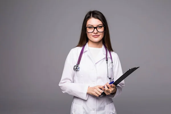 Vrouwelijke arts houden een klembord - geïsoleerd op een grijze achtergrond — Stockfoto