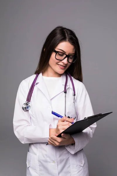 Doordachte jonge vrouw arts denken en schrijven op Klembord over greybackground — Stockfoto