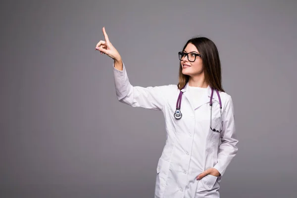 Leende glada läkare pekar med fingret på grå bakgrund — Stockfoto