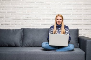 genç kadın, evde bir dizüstü bilgisayar kullanarak