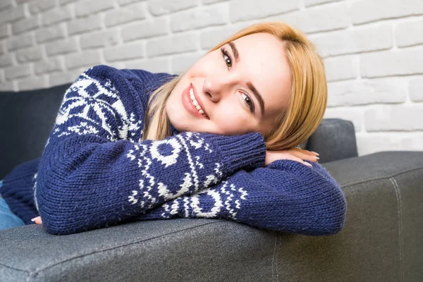 Fiatal nő casualwear látszó-on fényképezőgép-otthon a kanapén — Stock Fotó