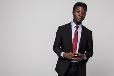 Tipik bir haber. Bir şey üstünde hareket eden telefon yazarak ve dururken Grey gülümseyen neşeli siyah manin takım elbise