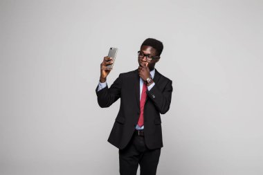 Genç mutlu Afrika işadamı selfie gri arka plan üzerine alarak