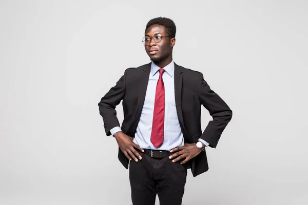 Guapo joven africano en traje, mientras que de pie sobre fondo gris —  Fotos de Stock