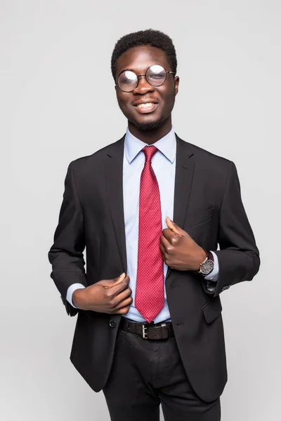 Retrato de un joven y apuesto hombre de negocios afroamericano vestido con un traje negro y corbata. Aislado sobre fondo gris —  Fotos de Stock