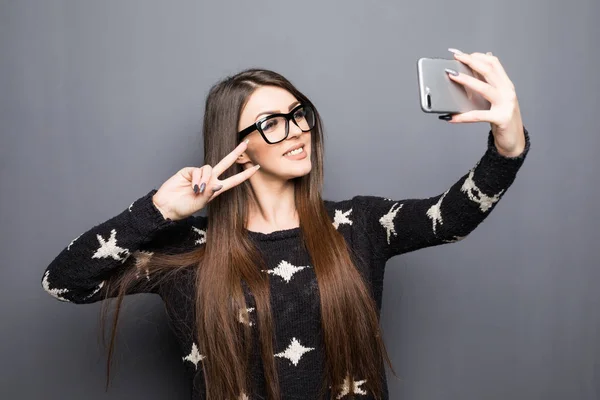 Alegre mujeres jóvenes haciendo selfie por su teléfono inteligente en gris — Foto de Stock