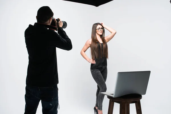 Fotograf som arbetar med modellen i utrustat vita studio — Stockfoto