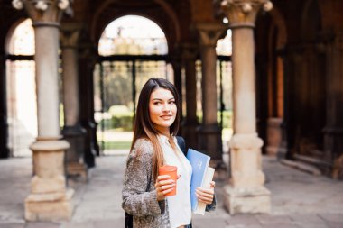 Genç güzellik öğrenci kız Notebook açık havada Üniversitesi içecek bir fincan kahve ile