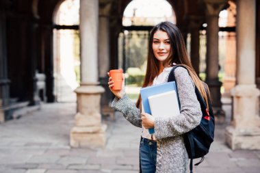 Genç güzellik öğrenci kız Notebook açık havada Üniversitesi içecek bir fincan kahve ile