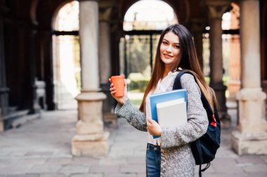 Genç güzellik öğrenci kız Notebook açık havada Üniversitesi içecek bir fincan kahve ile