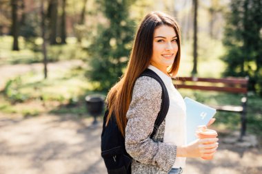 Üniversite kampüsünde dışında kamera gülümseyen güzel öğrenci