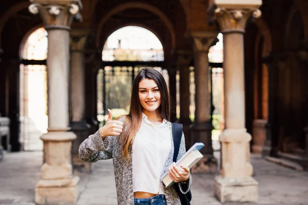 Portrait of a smiling female student showing thumb up outdoors — Stock Photo, Image