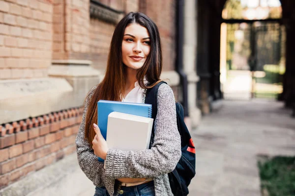 Красивая студентка улыбается перед камерой на кампусе университета — стоковое фото