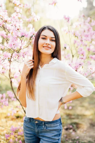 Portrait de jeune belle femme posant parmi les arbres en fleurs . — Photo