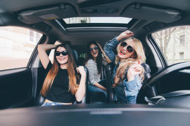 bir Cabrio araba sürüş ve having fun, üç kız dinle müzik ve dans