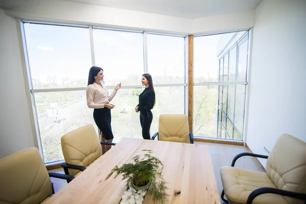 Två kvinnliga företagare att ha informella möte och tal på moderna kontor — Stockfoto