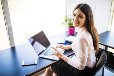 Onun çalışma evinde sandalyede otururken onu laptop kullanan genç güzel kadın