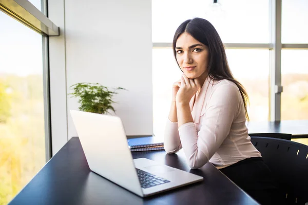 Ganska ung kvinna som arbetar på laptop i det moderna kontoret — Stockfoto