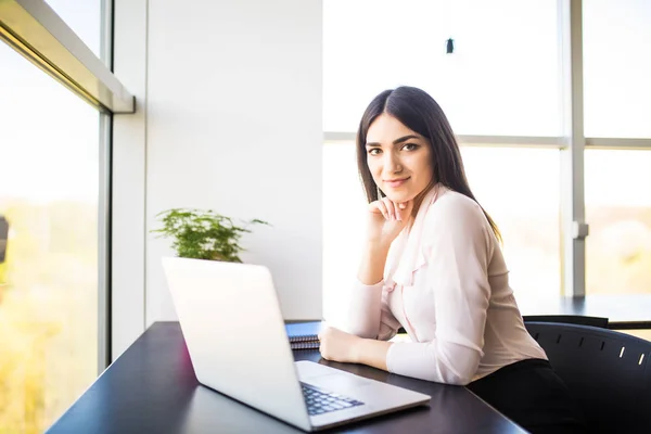 Ganska ung kvinna som arbetar på laptop i det moderna kontoret — Stockfoto