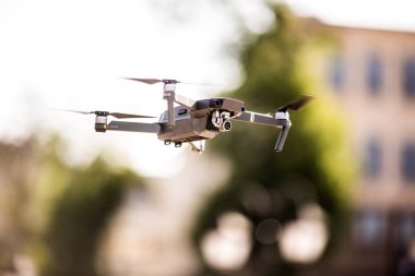 Drone dört helikopter ile şehrin üzerinde mavi gökyüzünde uçan uçan yüksek çözünürlüklü dijital kamera