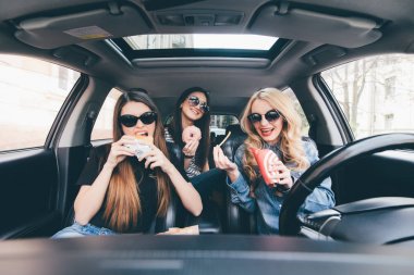 Üç genç kadın birbirlerini konuşma ve trafik sıkışıklığı bir araçta bir fast food yeme araba