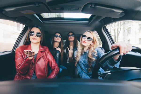 Group of friends having fun whet drive the car. Singing and laughing on the road