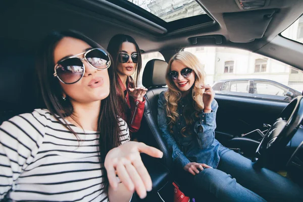 Groep meisjes plezier in de auto en het nemen van selfies met camera op reis — Stockfoto