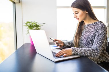güzel meşgul kadın portresi evde cep telefonu ve laptop aynı anda kullanma office