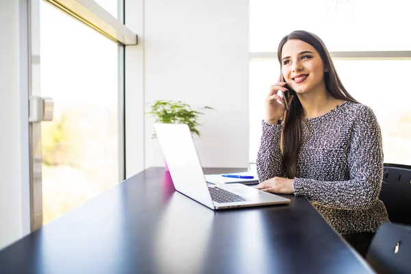 Freelancer mujer trabajando en línea y hablando por teléfono y navegando en una computadora portátil en casa u oficina — Foto de Stock