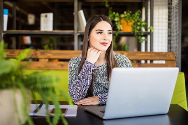 Elegant och glada affärskvinna. Glada unga vackra kvinnan tittar på kamera med leende medan du sitter på hennes arbetsplats — Stockfoto