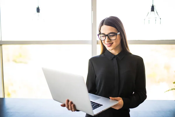 Portré sikeres üzletasszony laptop tartja a kezében. Boldog szép magabiztos nő állandó hivatal-val Jegyzetfüzet. — Stock Fotó