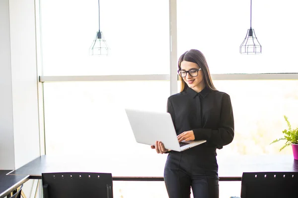 Portret van succesvolle zakenvrouw met laptop in haar handen. Gelukkig mooi vertrouwen vrouw op kantoor met laptop. — Stockfoto