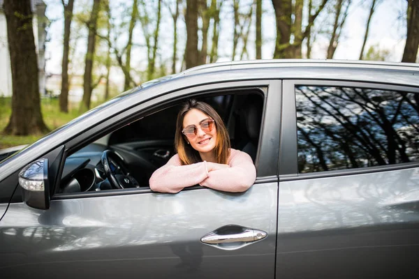 Atractiva joven hembra mira por la ventana del coche esperando un viaje — Foto de Stock