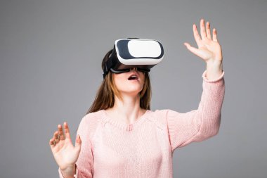 Gri arka plan üzerinde izole Vr aygıt ile izlerken kadın