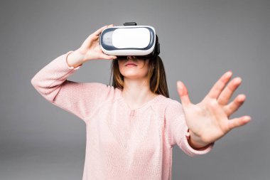 sanal gerçeklik kulaklık, kapalı beyaz arka plan üzerinde ateş üzerinden seyir çekici genç kadın. beyaz kadın modeli VR gözlük takıyor arıyorum.