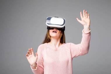 Gri arka plan üzerinde izole Vr aygıt ile izlerken kadın